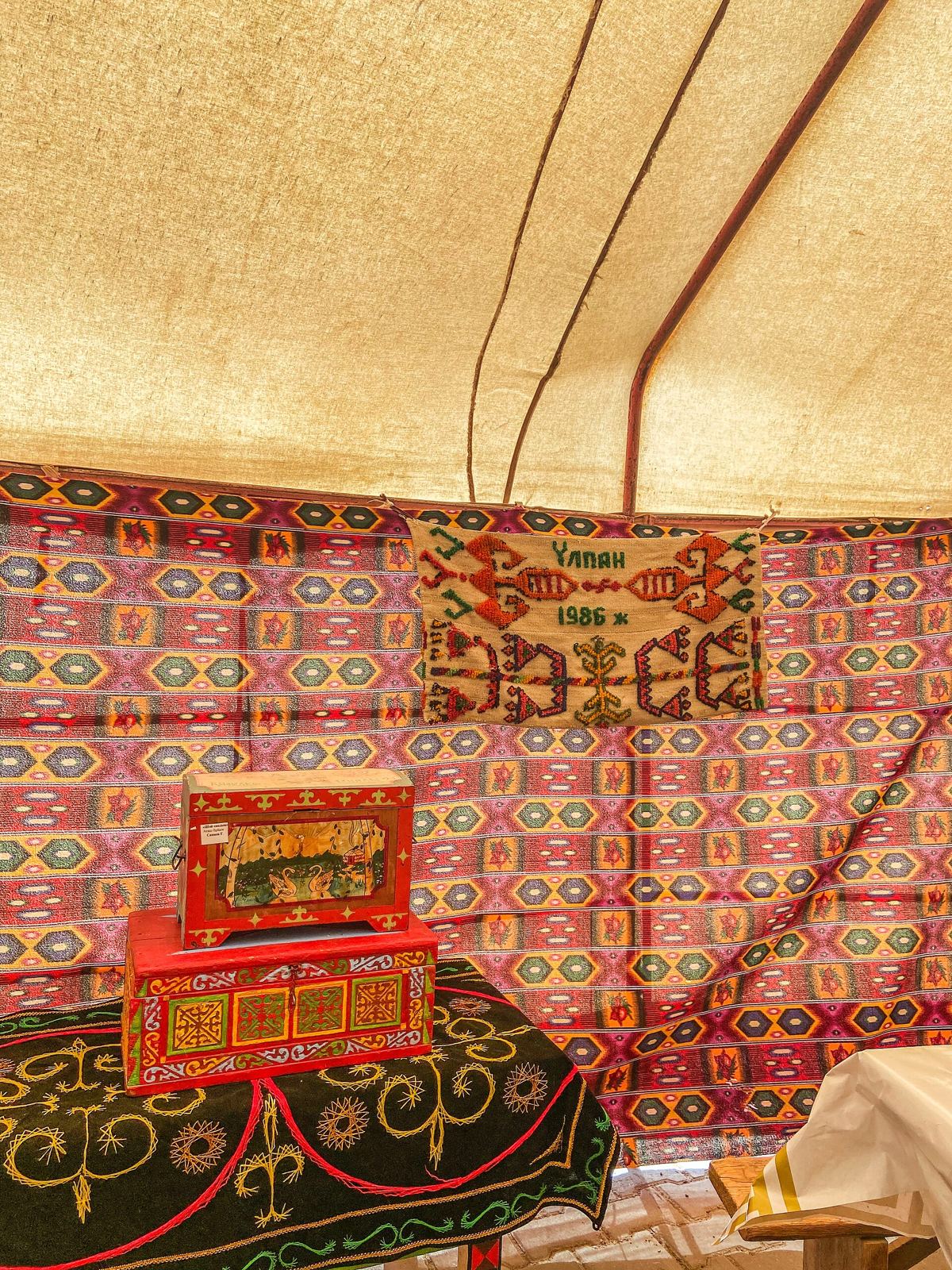 Felt carpets and painted chests inside a Kazakh yurt